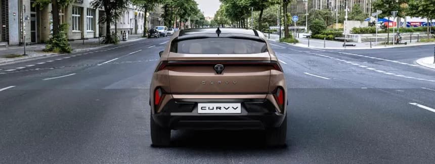 Premium electric coupe SUV parked on scenic coastal highway at sunset